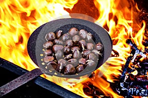 Roasting chestnuts in a skillet with holes on the fire