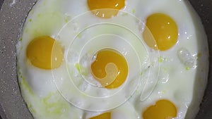 Roasting eggs in a frying pan. Scrambled eggs are fried in a frying pan, there is steam