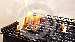 Roasting juicy meat steak with spices and herbs in burning charcoals fire on bbq grid, flames and smoke.