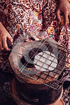 Roasting Khao Kriab or rice flour local snack of Ban Nam Chiao,