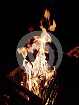 Roasting marshmallows on campfire in steel fire pit