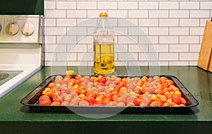 Roasting pan with a Grappoli d`Inverno winter grape tomatoes and a bottle of Italian olive oil photo