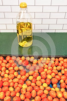 Roasted grape tomatoes and a bottle of Italian olive oil photo