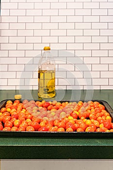 Roasting pan with `a Grappoli d`Inverno` winter grape tomatoes and a bottle of Italian olive oil photo