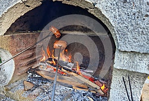 Roasting sausages over campfire