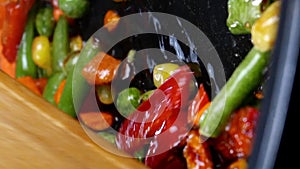 Roasting traditional mexican vegetables mix corn, red bell pepper, green beans, green peas and carrot in frying pan