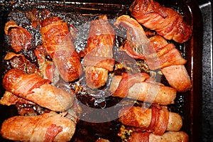 Roasting tray full of Sausages wrapped in Bacon