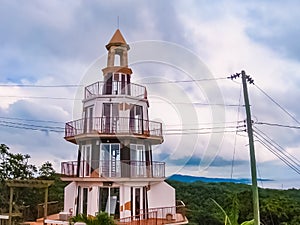 Roatan, Honduras, El Faro Lighthouse in West Bay. Landscape of the island with a blue sky and green vegetation in the background