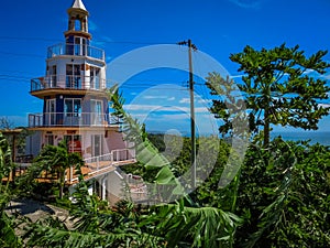 Roatan, Honduras Lighthouse building. Landscape of the island with a blue sky and green vegetation in the background.