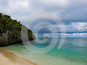 Roatan island Honduras. Landscape of a tropical blue turquoise clear ocean water and sandy beach. Blue dramatic cloudy sky in the