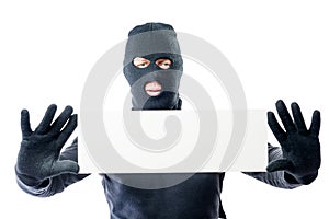 Robber in black clothes and mask with a poster in hands