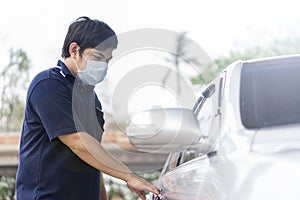 Robber and the car thief in a mask opens the door of the car and hijacks the car