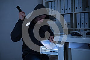 Robber With Flashlight Searching For Documents In Office