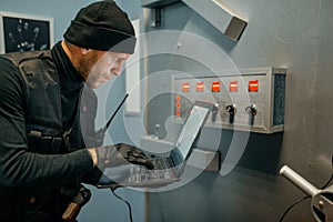 Robber with laptop trying to open the vault door