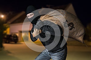 Robber runs away and is carrying full bag of money at night.