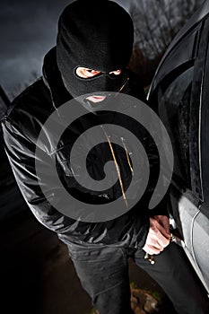 Robber and the thief in a mask hijacks the car