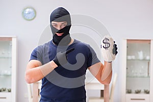 The robber wearing balaclava stealing valuable things