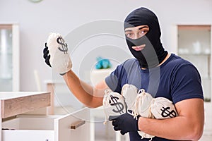 The robber wearing balaclava stealing valuable things