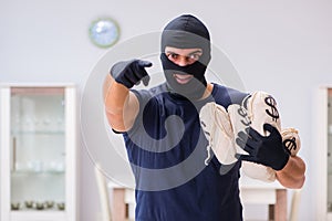 The robber wearing balaclava stealing valuable things