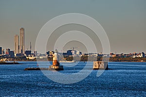 Robbins Reef Lighthouse in New York City with Golden light and industrial city behind