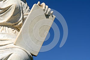 Robed person holding stone tablet