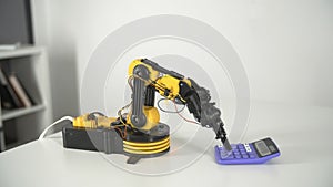 Robot Arm with Calculator. Experiment with Intelligent Manipulator. Industrial Robot Model.