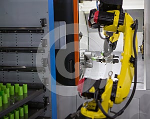 Robot arm loading workpieces on CNC lathe machine