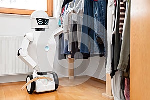 Robot with clothes in front of the wardrobe