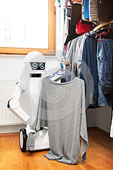 Robot with clothes in front of the wardrobe