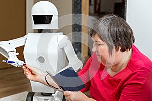 Robot friend is learning or teaching with an disabled woman, reaching her a pencil