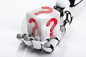 Robot Holding Cubic Block With Question Mark Sign