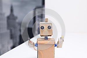 Robot holding a wire and a light emitting diode on white table