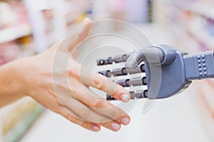 Robot and human hands in handshake, high tech in everyday life photo