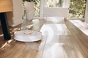 Robot vacuum cleaner does house cleaning close-up. Use of modern technology for cleaning