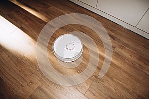 Robot vacuum cleaner does house cleaning close-up. Use of modern technology for cleaning