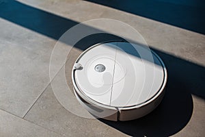 Robot vacuum cleaner on laminate floor in apartment