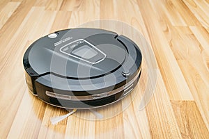 Robot vacuum cleaner on laminate wood floor, Home Smart robotic.