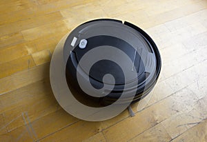 Robot vacuum cleaner on laminate wood floor, Smart robotic automate wireless cleaning technology machine in living room