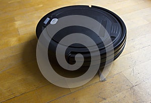 Robot vacuum cleaner on laminate wood floor, Smart robotic automate wireless cleaning technology machine in living room