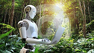 Robot working on laptop computer in the green forest. AI Generated