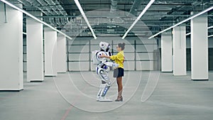 Robotic anthropoid and a lady are holding each other