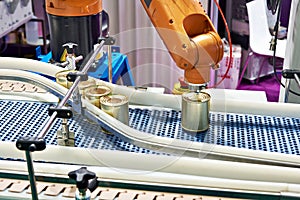 Robotic arm and cans on conveyor