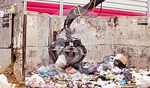 Robotic arm of garbage truck taking gabbage