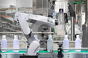 Robotic arm holding water bottles on drink production line