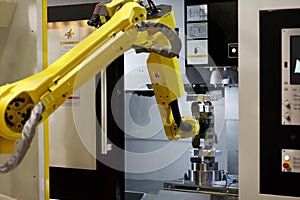 Robotic arm loads a workpiece into the CNC machine photo