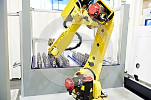 Robotic arm and metal workpieces photo
