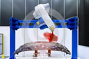Robotic arm painting spray to the automotive part. High-technology manufacturing concept