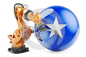 Robotic arm with Somali flag. Modern technology, industry and production in Somalia concept, 3D rendering