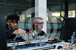 The robotic hand technology teacher is instructing new students on how to use electronic circuit boards and robotic hand commands