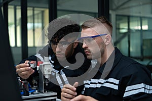 The robotic hand technology teacher is instructing new students on how to use electronic circuit boards and robotic hand commands